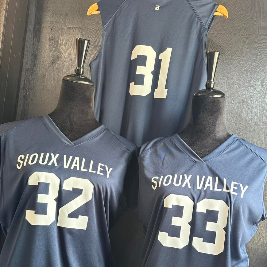 Three blue sleeveless jerseys with numbers and 'Sioux Valley' text on mannequins against a dark background. Basketball Jerseys
