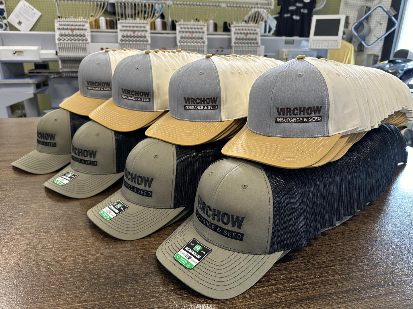 Stack of Virchow hats on a wooden surface with sewing machines in the background