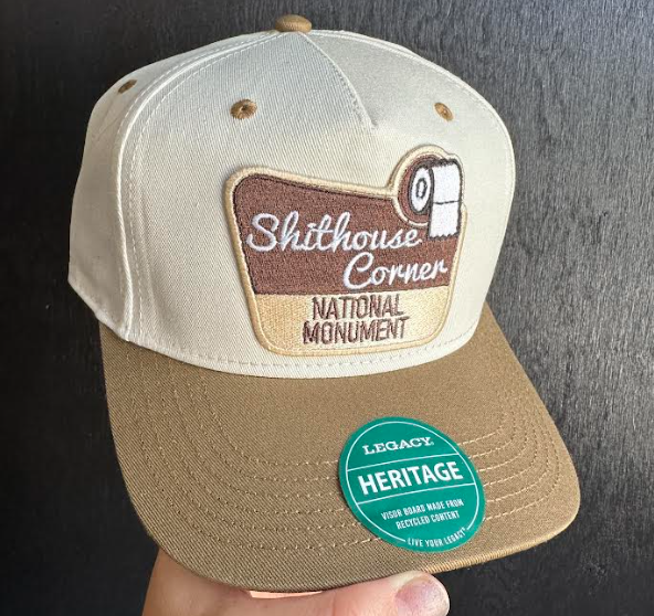 Cap with 'Shithouse Corner National Monument' logo and 'Legacy Heritage' label on a dark background